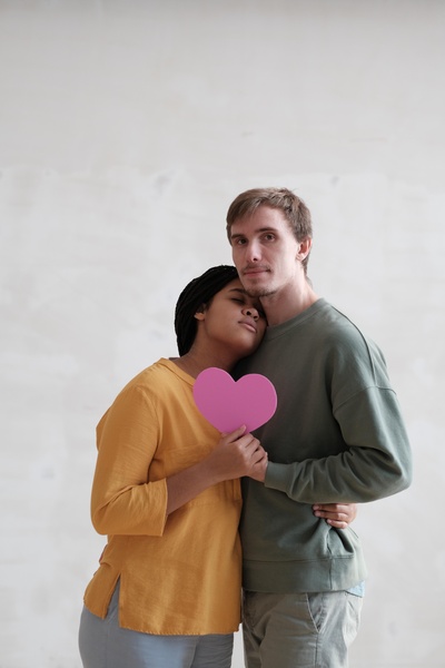 Couple Hugs and Holds Heart-Shaped Card